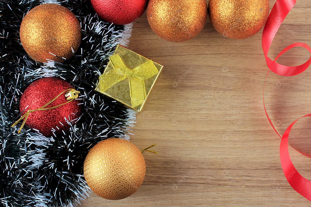 fundo de madeira, decoração de natal com bolas e presentes, galhos de árvores decorativas, vista frontal