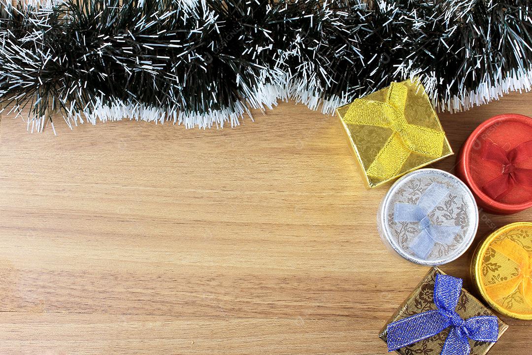 fundo de madeira, decoração de natal com bolas e presentes, galhos de árvores decorativas, vista frontal