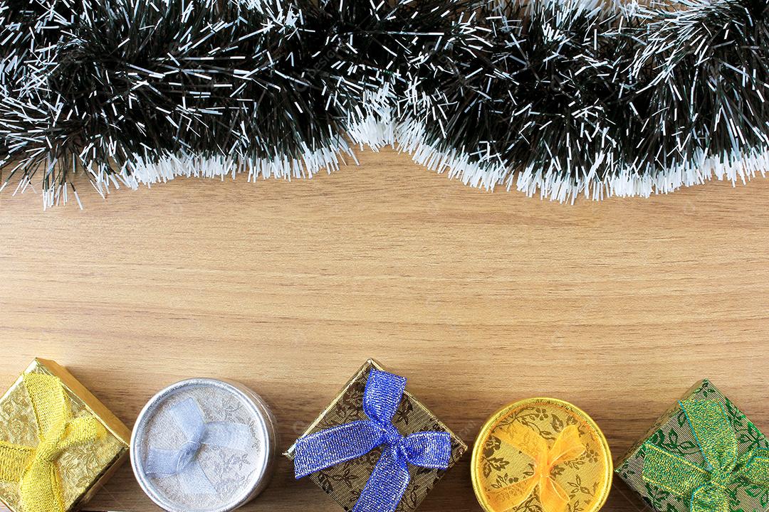 fundo de madeira, decoração de natal com bolas e presentes, galhos de árvores decorativas, vista frontal