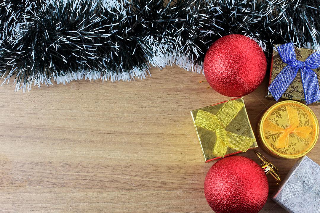 fundo de madeira, decoração de natal com bolas e presentes, galhos de árvores decorativas, vista frontal