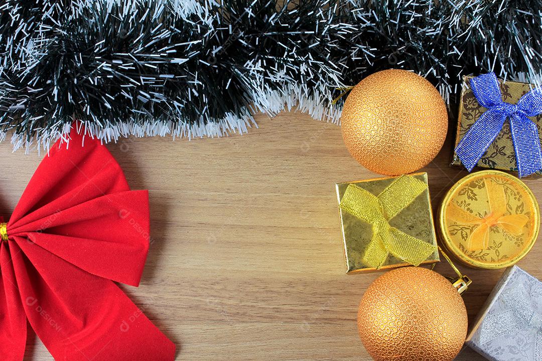 fundo de madeira, decoração de natal com bolas e presentes, galhos de árvores decorativas, vista frontal