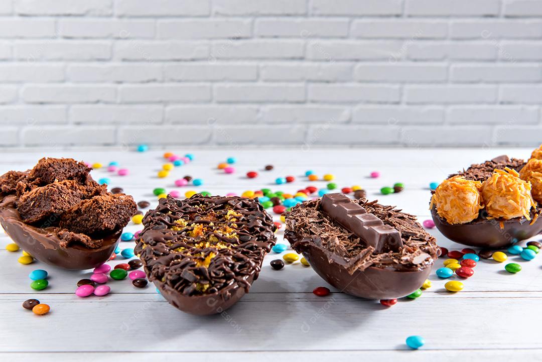 Conceito de páscoa, ovos de páscoa cheios de chocolate em fundo branco com foco seletivo de confete