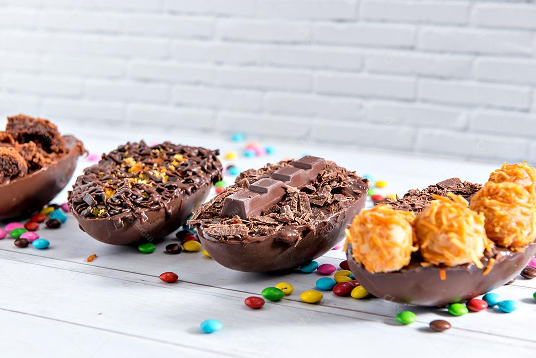 Conceito de páscoa, deliciosos ovos de páscoa cheios de chocolate em fundo branco com foco seletivo de confete