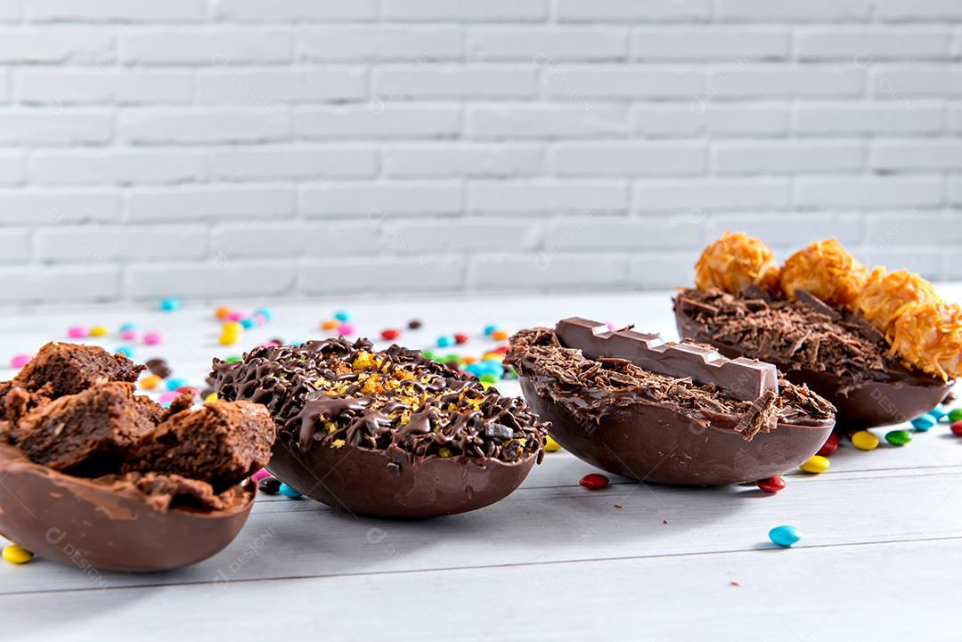 Conceito de páscoa, deliciosos ovos de páscoa cheios de chocolate em fundo branco com foco seletivo de confete