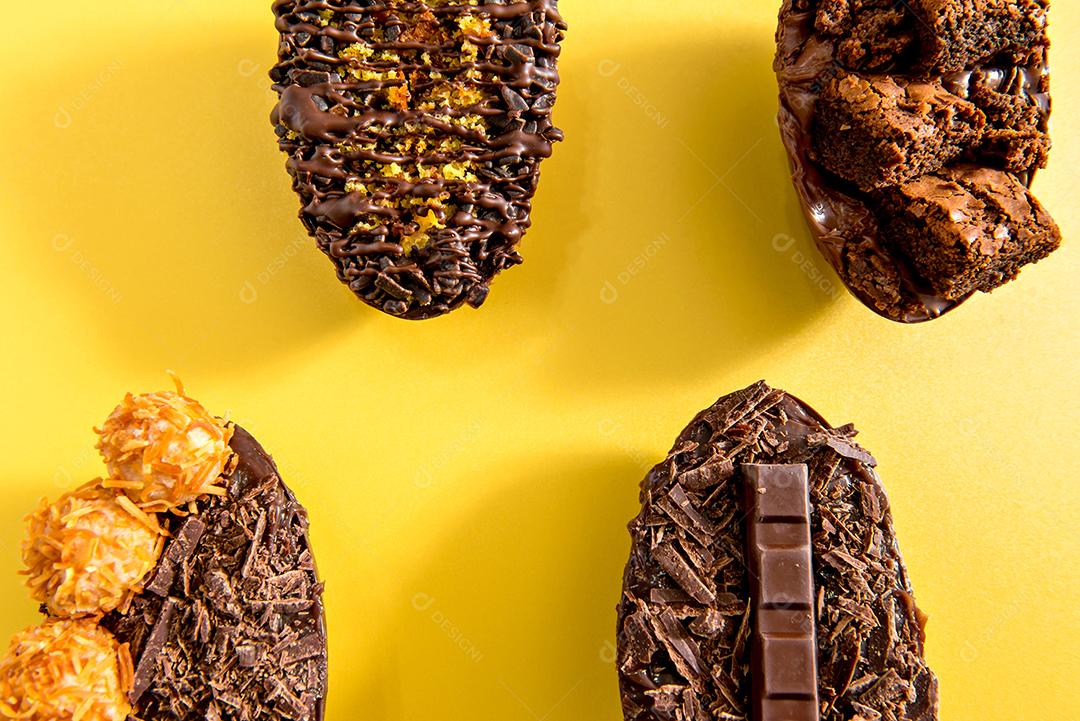 Deliciosos ovos de páscoa cheios de chocolate em fundo amarelo.