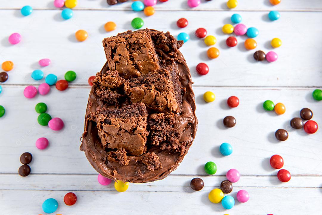 Conceito de páscoa, ovos de páscoa cheios de chocolate e brownie em fundo branco com confete