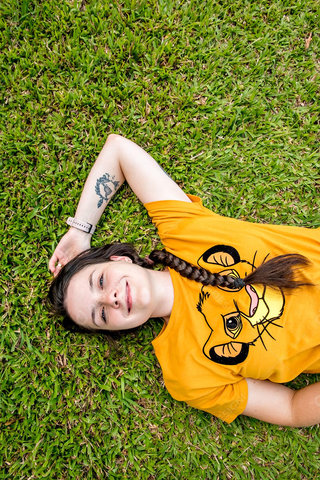 garota feliz deitada na grama