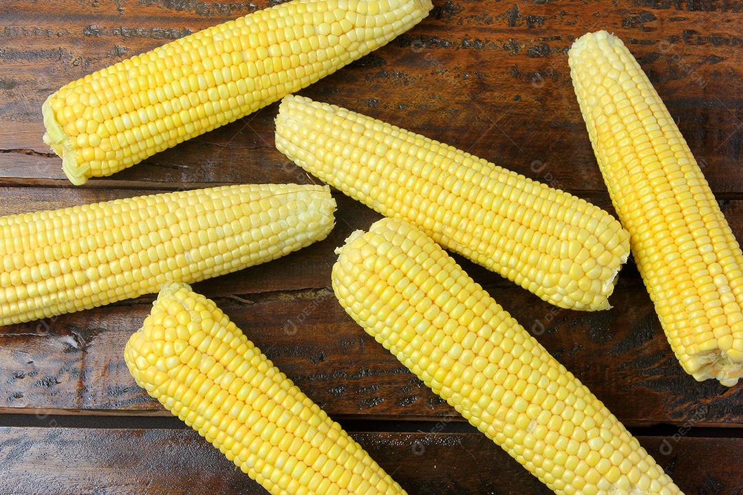 espiga de milho cru, colhida da plantação, na mesa de madeira rústica. Vista do topo