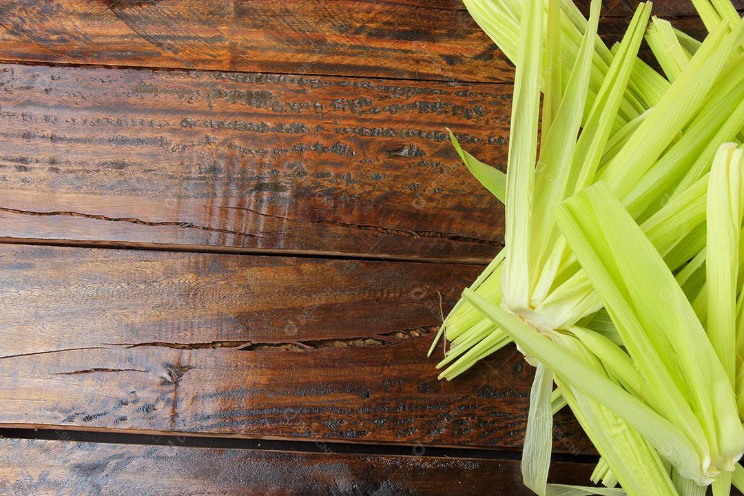 casca e palha de milho verde, colhidas da plantação, na mesa de madeira rústica