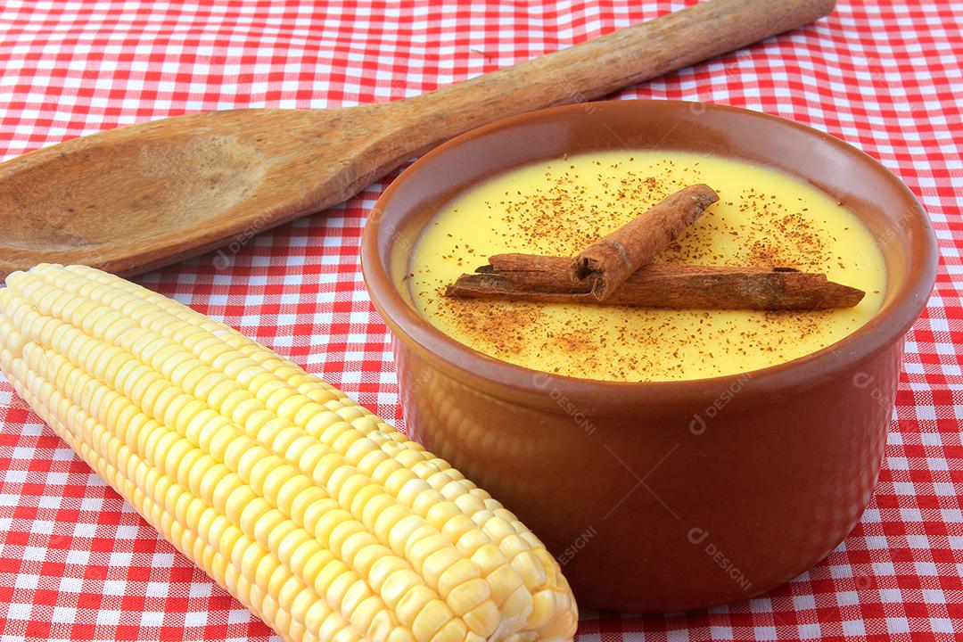 curau, creme de milho doce e sobremesa típica da culinária brasileira, com canela colocada em tigela de cerâmica sobre toalha xadrez