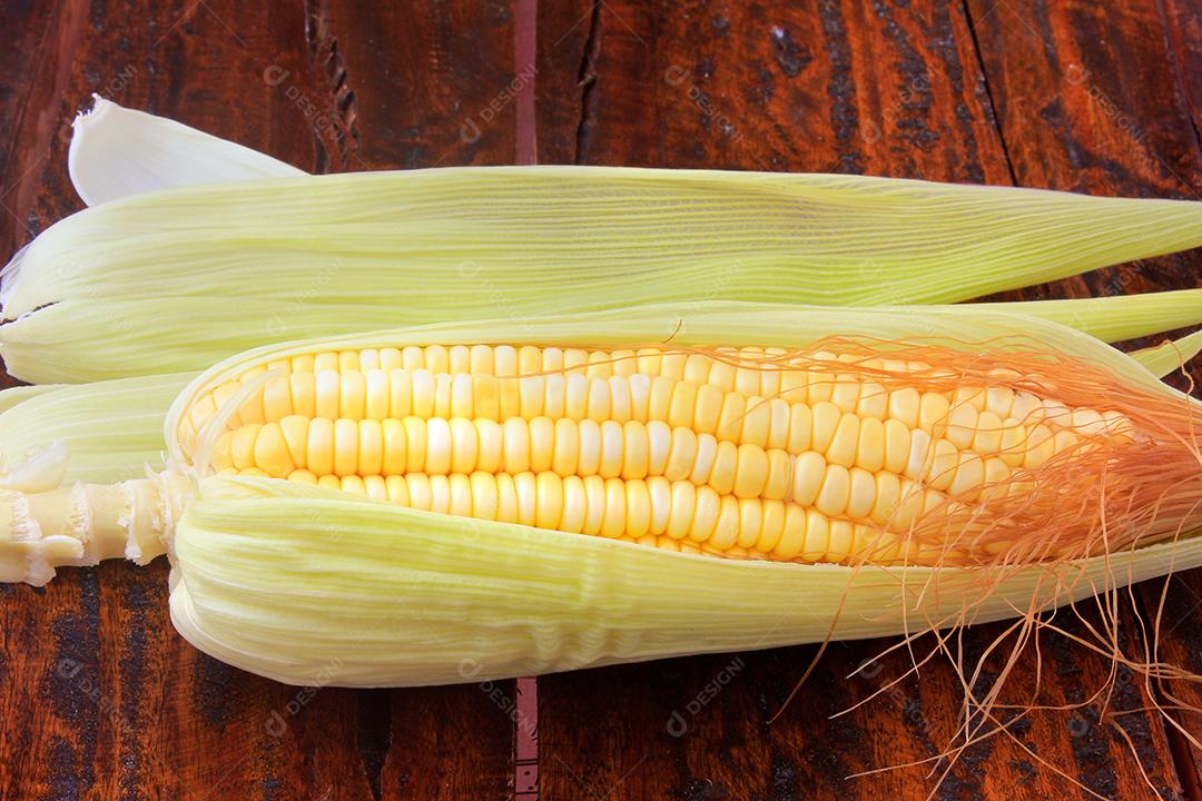 espiga de milho cru e fresco isolado na mesa de madeira rústica