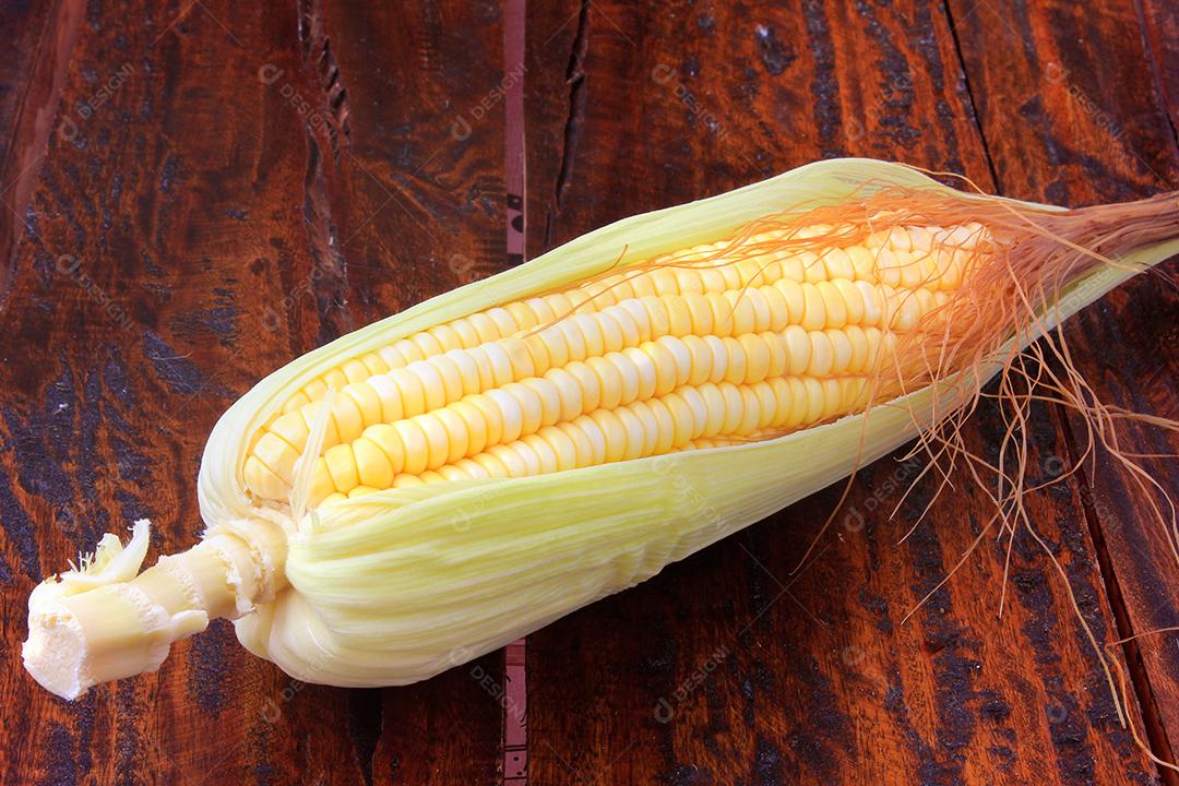 espiga de milho cru e fresco isolado na mesa de madeira rústica