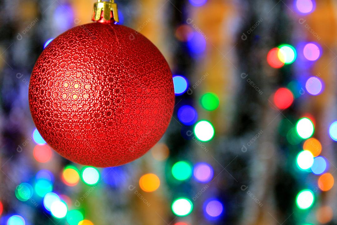 Bola vermelha pendurada decoração de natal com fundo de luzes desfocadas