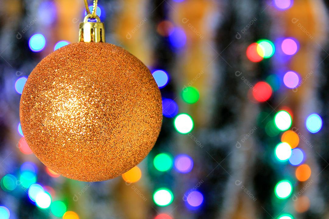 Bola dourada pendurada, decoração de natal com fundo de luzes desfocadas