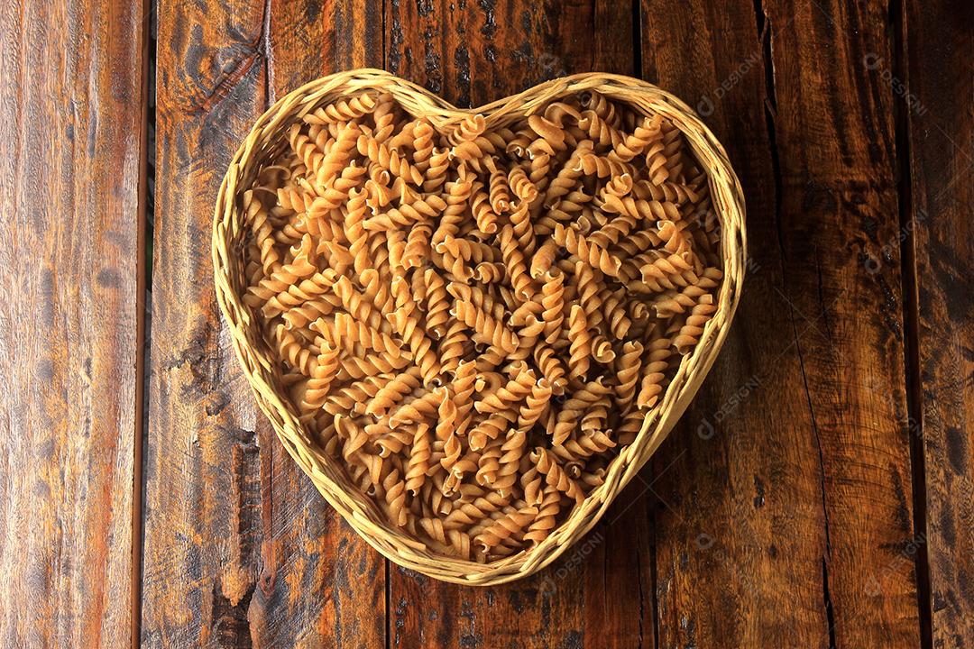 Vista superior Massa integral fusilli grãos inteiros orgânicos crus em uma madeira rústica