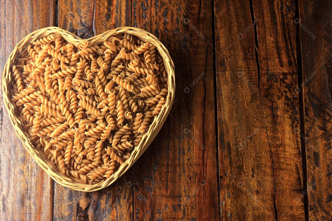 Vista superior Massa integral fusilli grãos inteiros orgânicos crus em uma madeira rústica