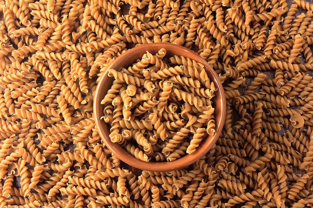 Vista superior Massa integral fusilli grãos inteiros orgânicos crus em uma madeira rústica