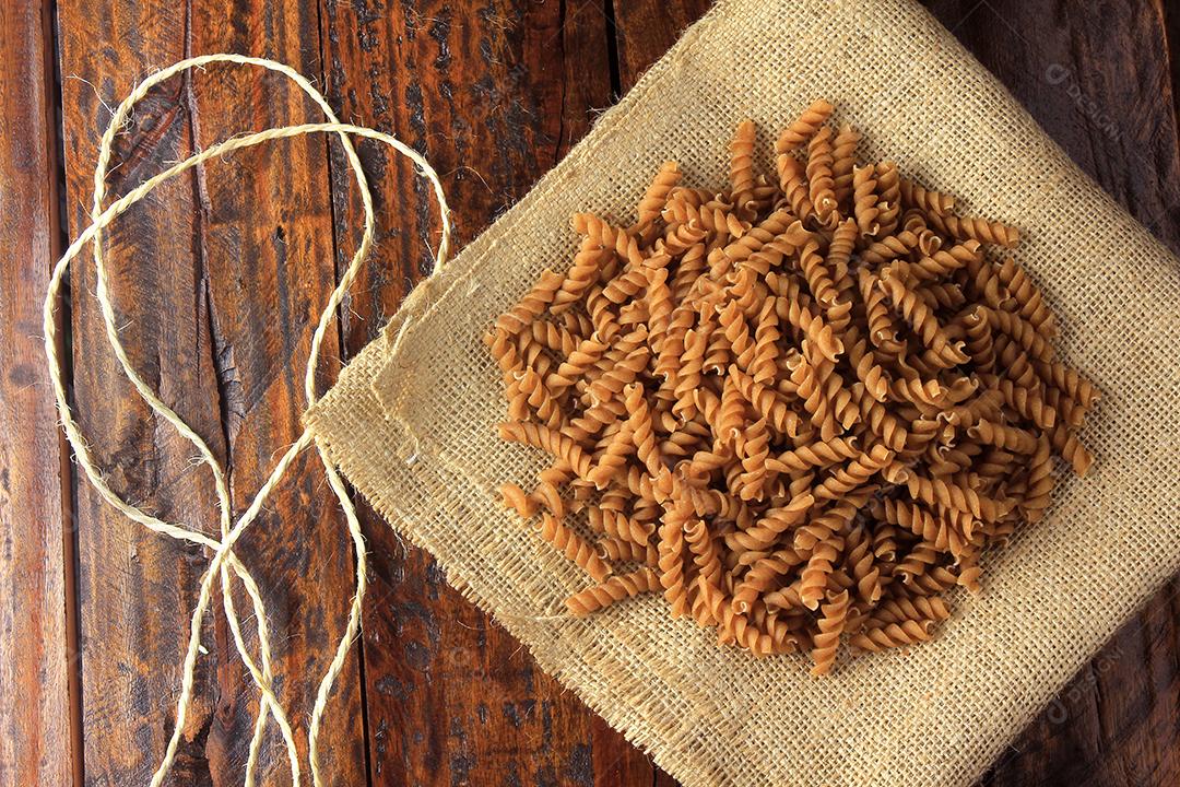 Vista superior de toda a massa de Fusilli em tecido toalha áspera sobre fundo de madeira