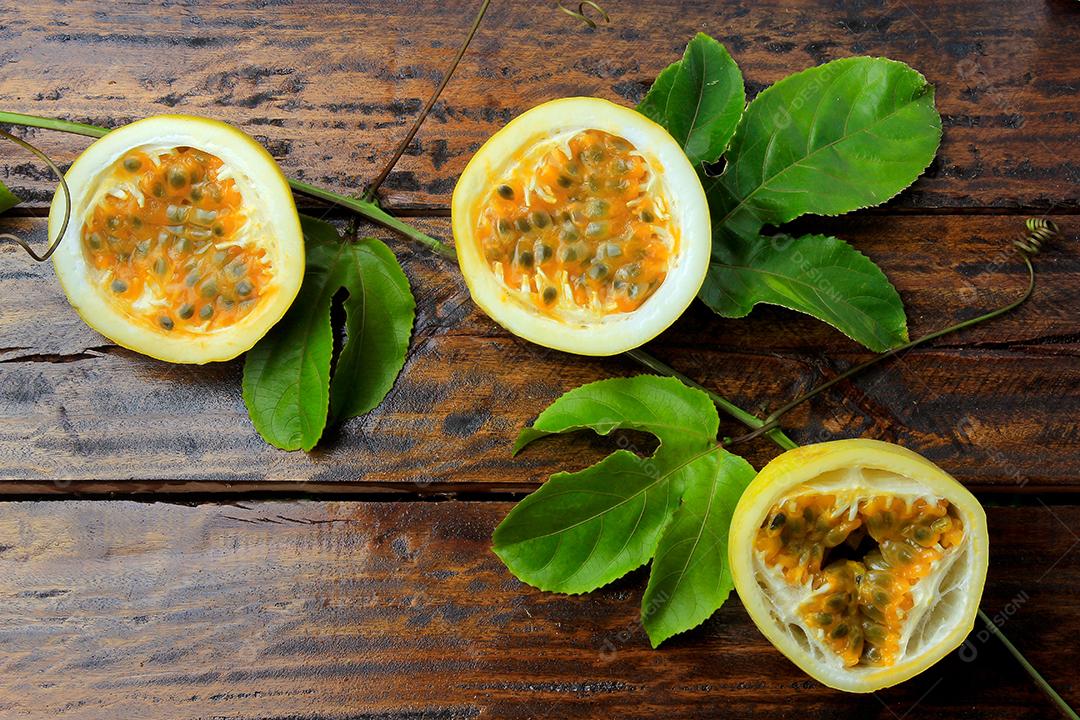 ramos e folhas com maracujá amarelo isolados na mesa de madeira. Vista superior de perto