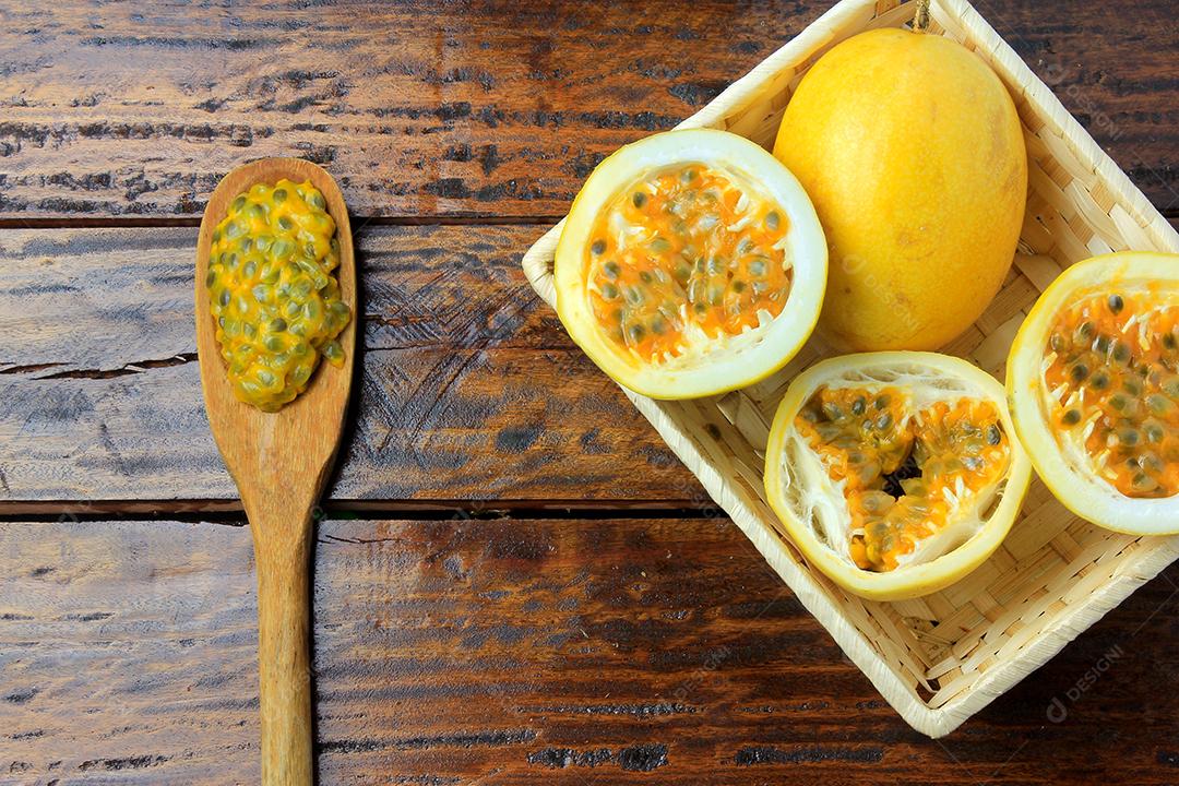 ramos e folhas com maracujá amarelo isolados na mesa de madeira. Vista superior de perto