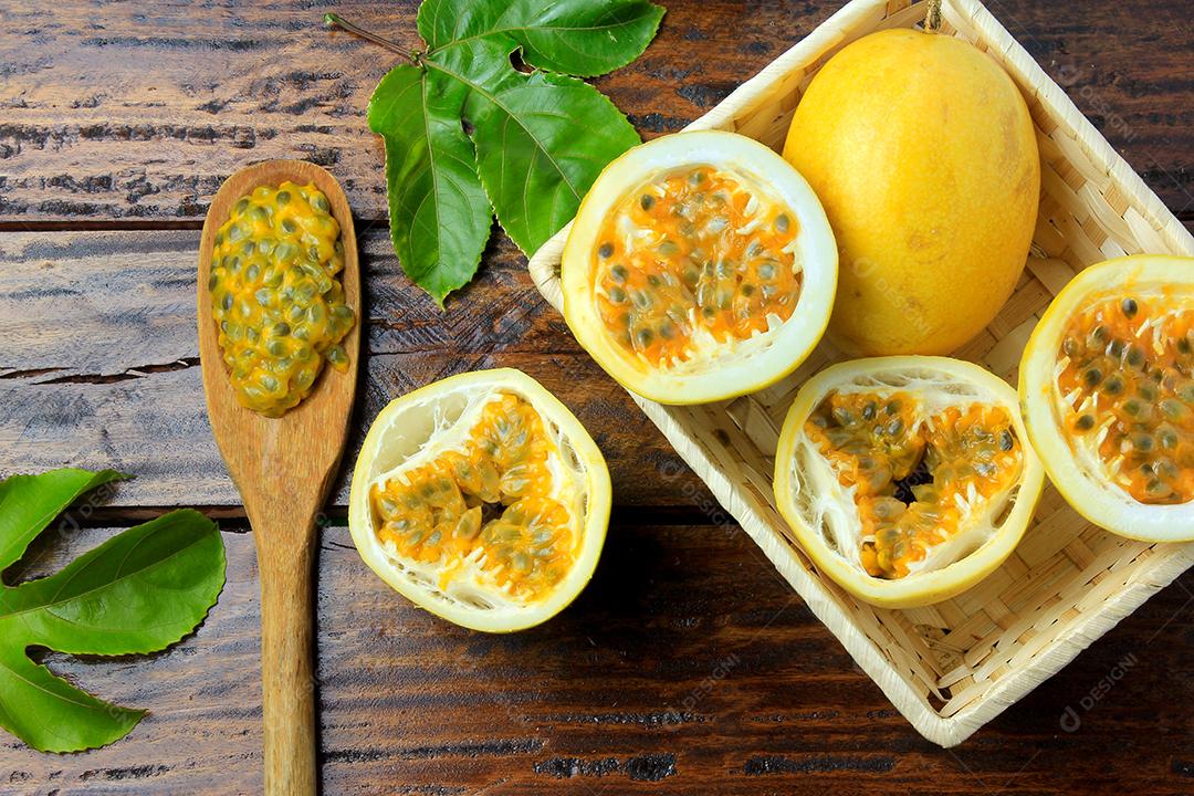 ramos e folhas com maracujá amarelo isolados na mesa de madeira. Vista superior de perto