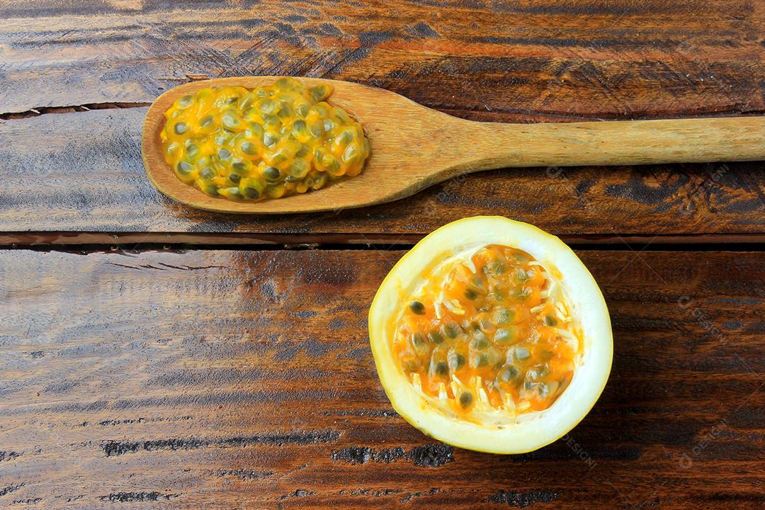 ramos e folhas com maracujá amarelo isolados na mesa de madeira. Vista superior de perto