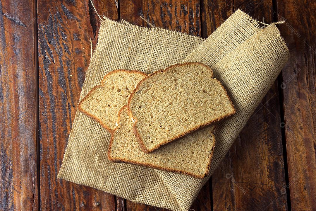 Pão integral orgânico fatiado, feito de aveia e sementes de linho em tecido rústico. Dieta saudável. Vista do topo