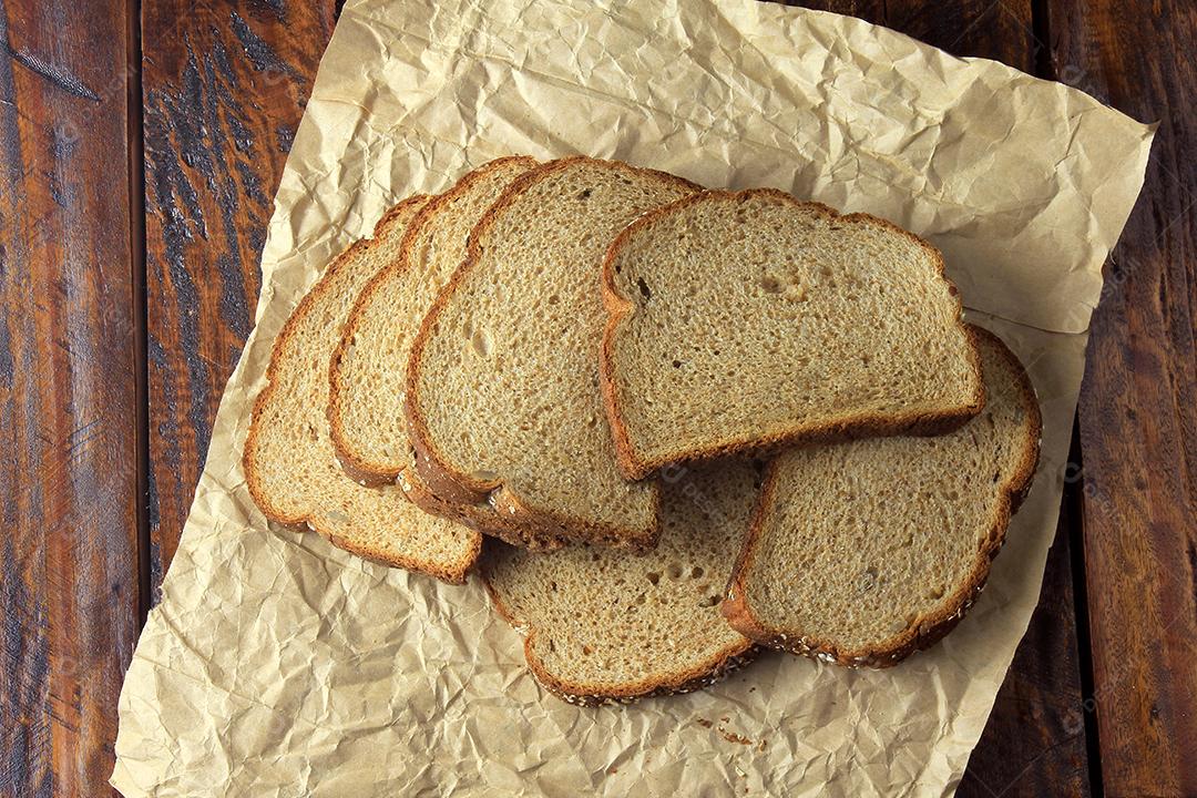 Pão integral orgânico fatiado, feito de aveia e sementes de linho em tecido rústico. Dieta saudável. Vista do topo