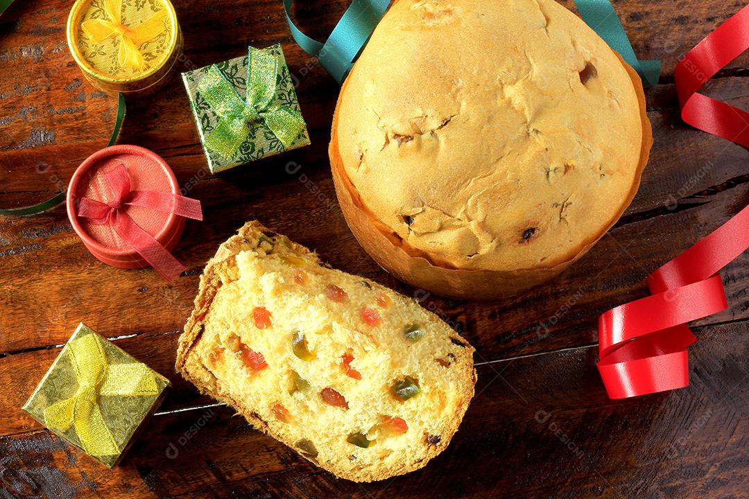 Decoração de natal feita com panetone e presentes isolados em fundo de madeira rústico. vista do topo