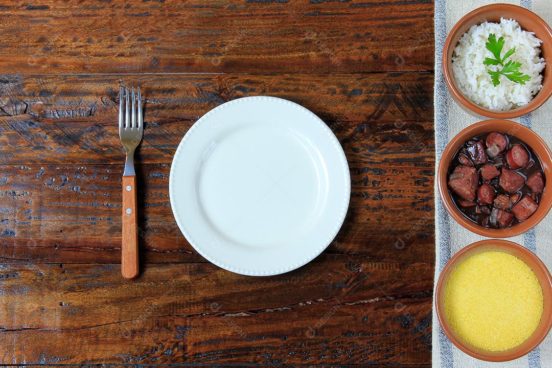 Feijoada brasileira, prato tradicional da culinária brasileira, na mesa de madeira. vista do topo