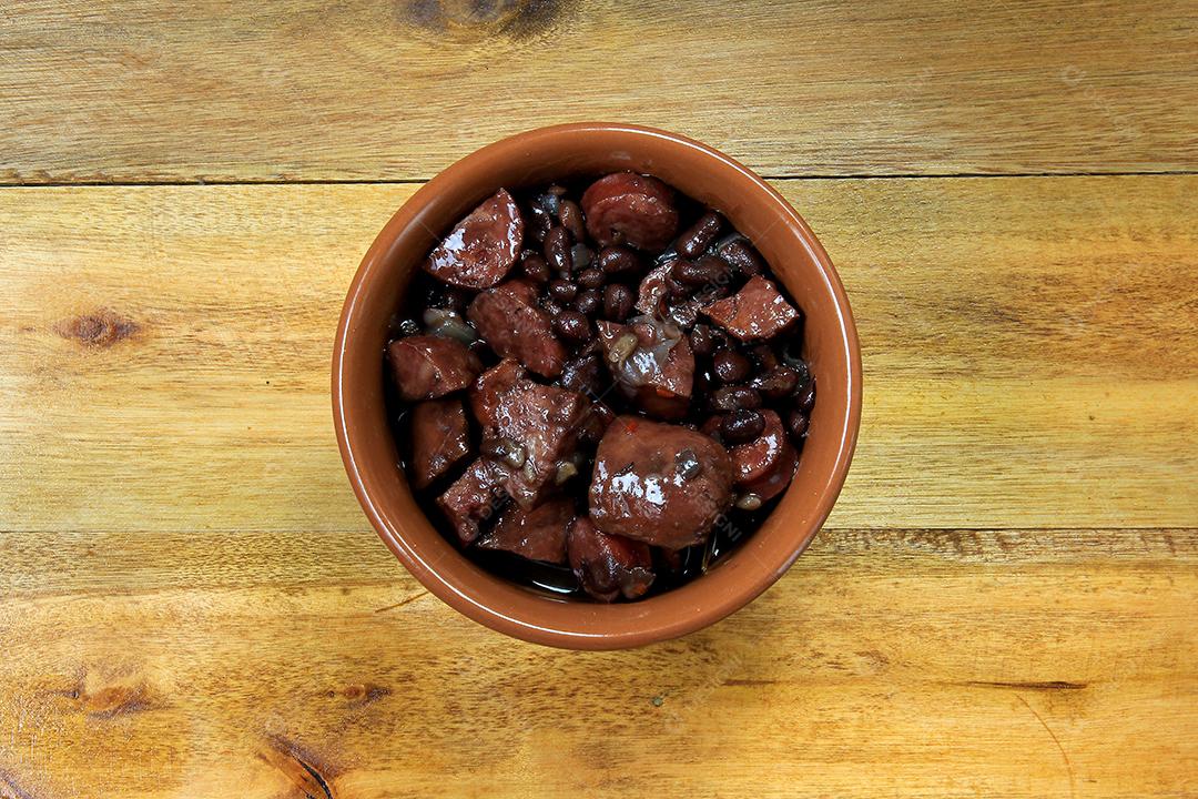 Feijoada brasileira, prato tradicional da culinária brasileira, na mesa de madeira. vista do topo