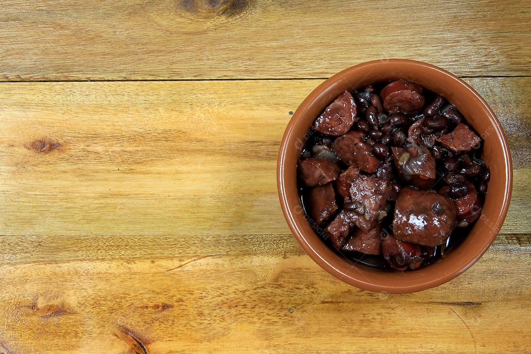 Feijoada brasileira, prato tradicional da culinária brasileira, na mesa de madeira. vista do topo