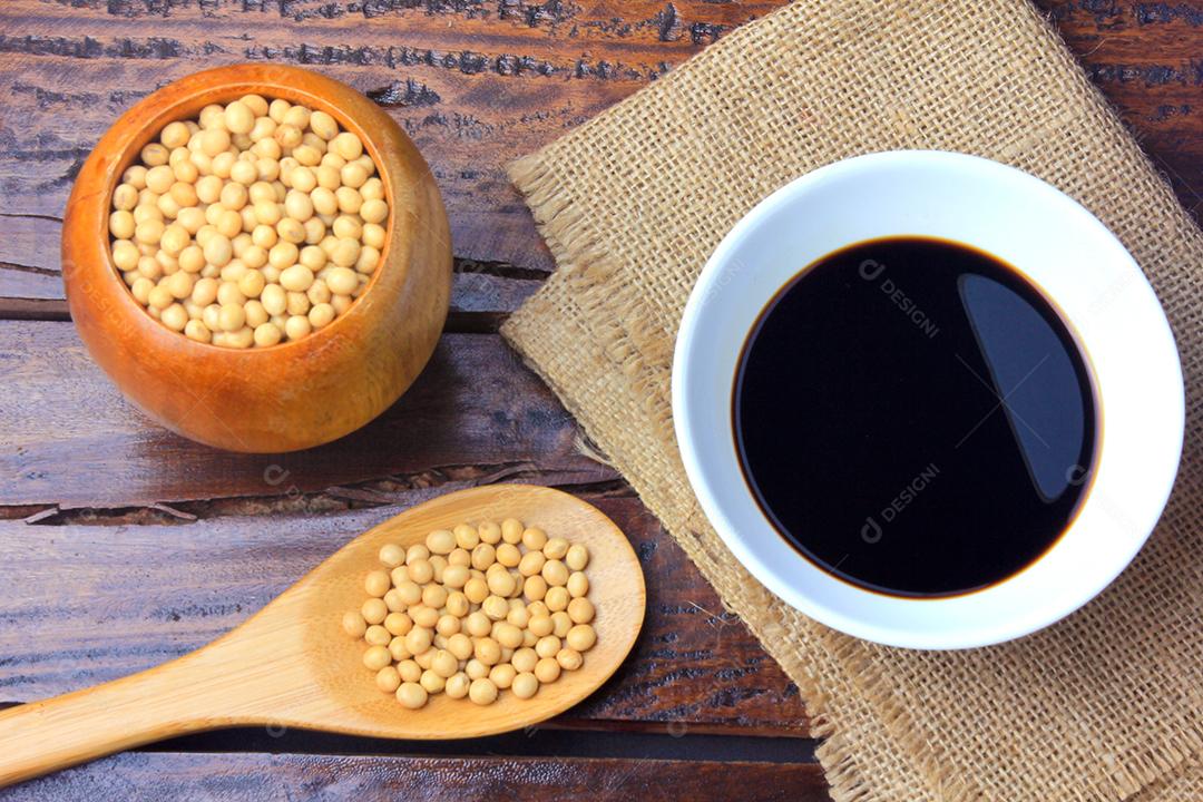 Feijão de soja com molho de soja escuro em uma tigela de cerâmica na mesa de madeira rústica