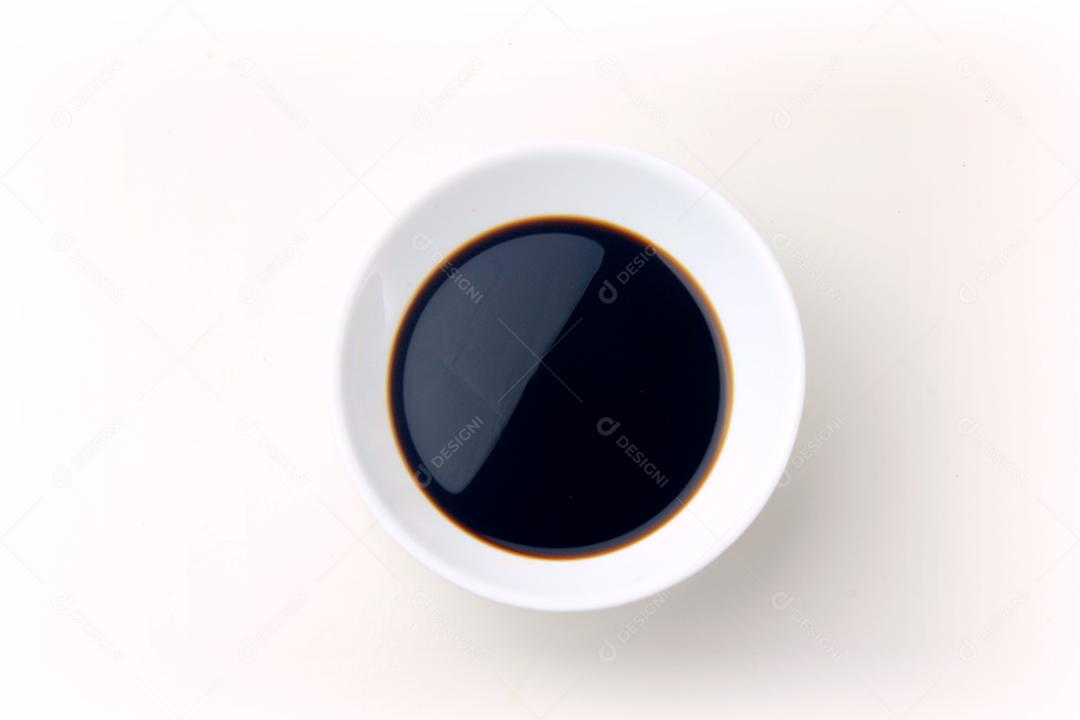 Molho de soja em uma tigela de cerâmica isolada no fundo branco, com traçado de recorte. Copiar espaço