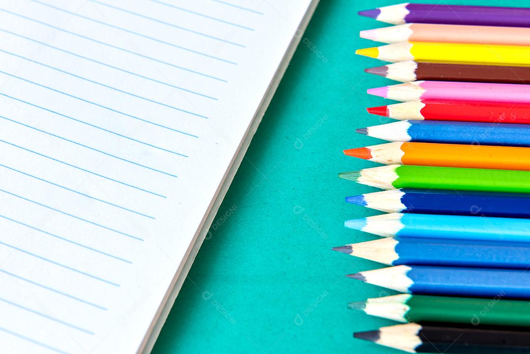 Material escolar, caderno e lápis de cor.