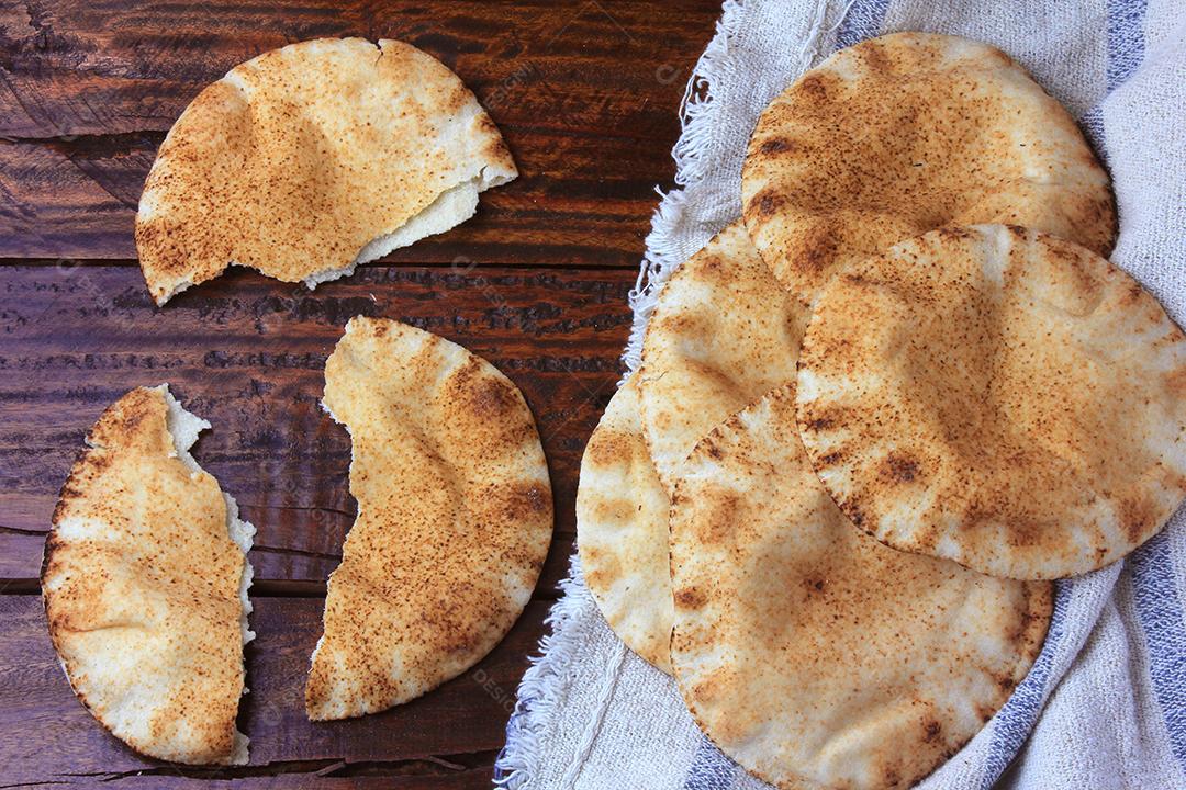 Pão pita isolado na mesa de madeira rústica em pano rústico. Comida tradicional e típica da culinária árabe