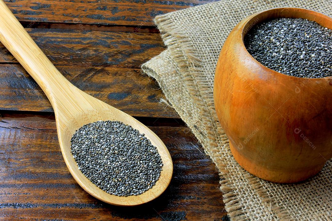 Chia seeds in wooden bowl isolated on rustic table