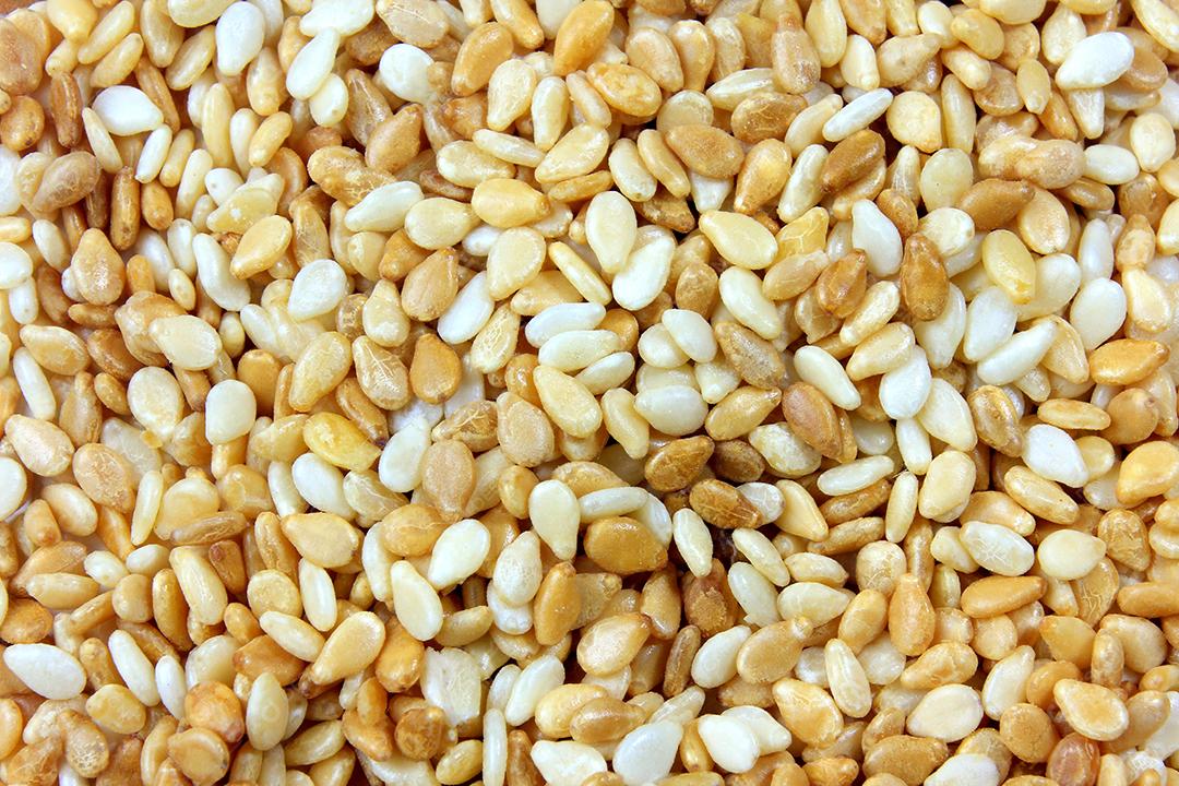 Sementes de gergelim ampliadas formando fundo preenchido com suas sementes. Vista do topo