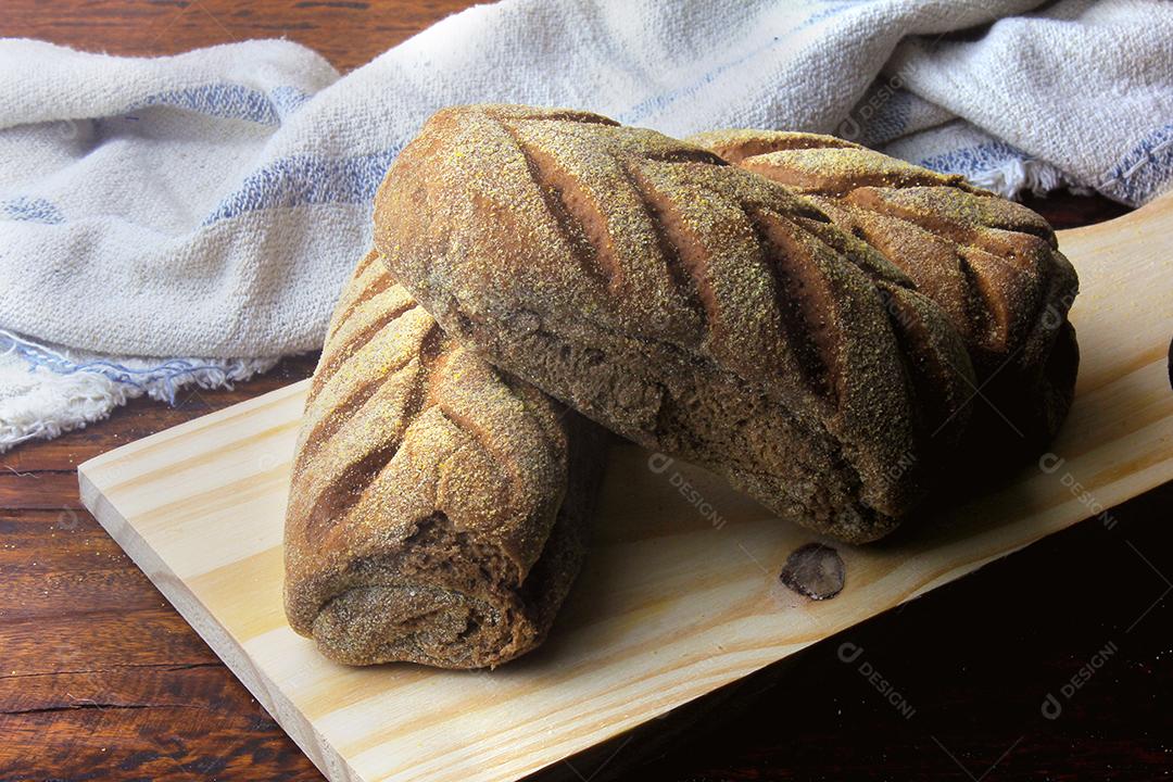 Pão australiano na espátula, saindo do forno, sobre fundo de madeira rústico. Tradicionalmente este pão