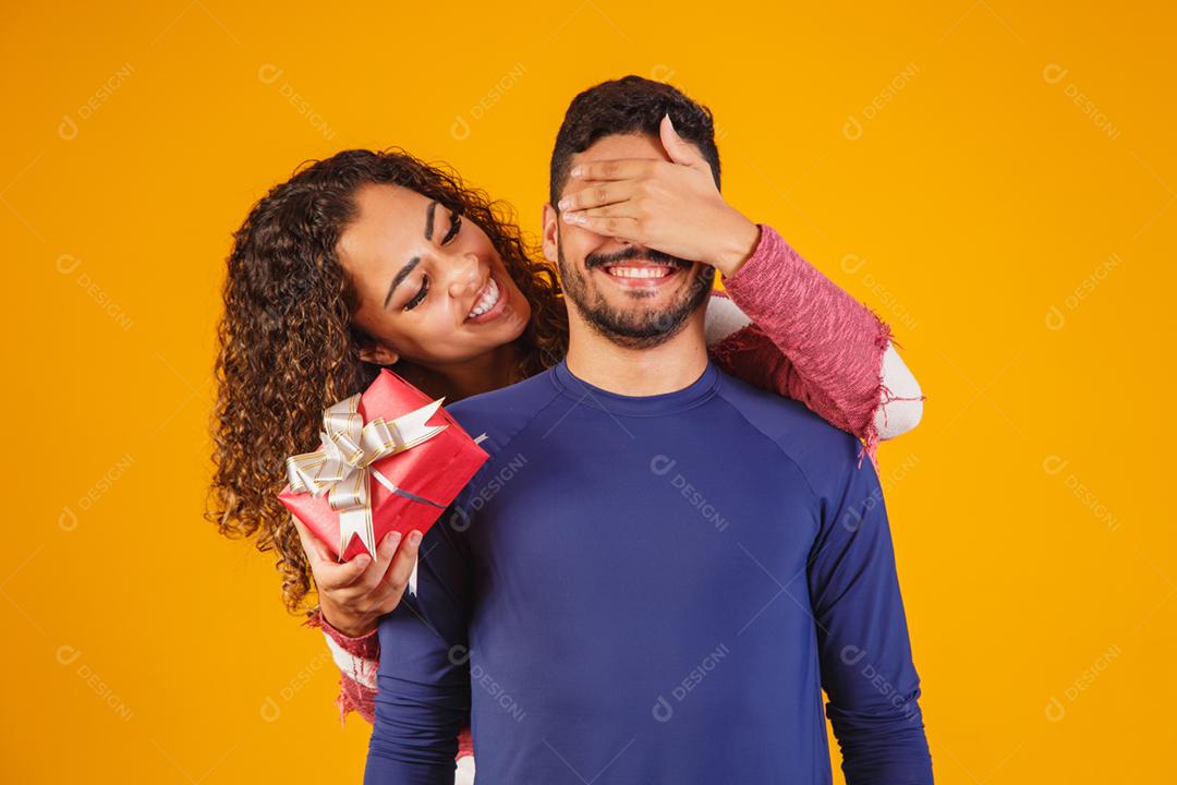 Alegre e animado jovem casal isolado sobre um amarelo