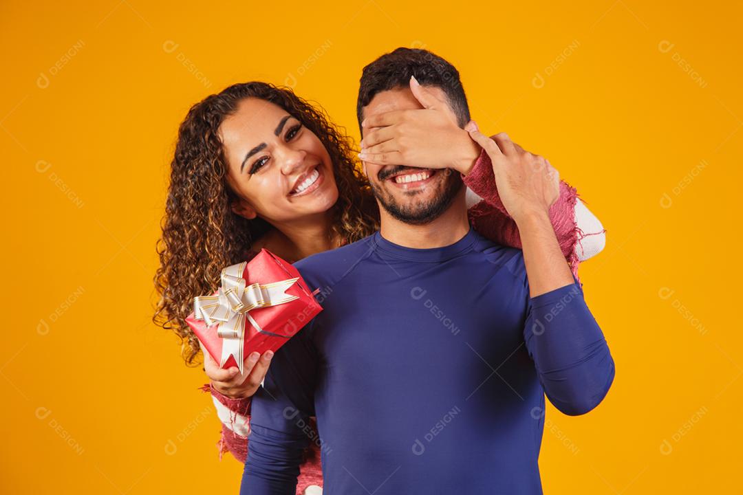 Alegre e animado jovem casal isolado sobre um amarelo