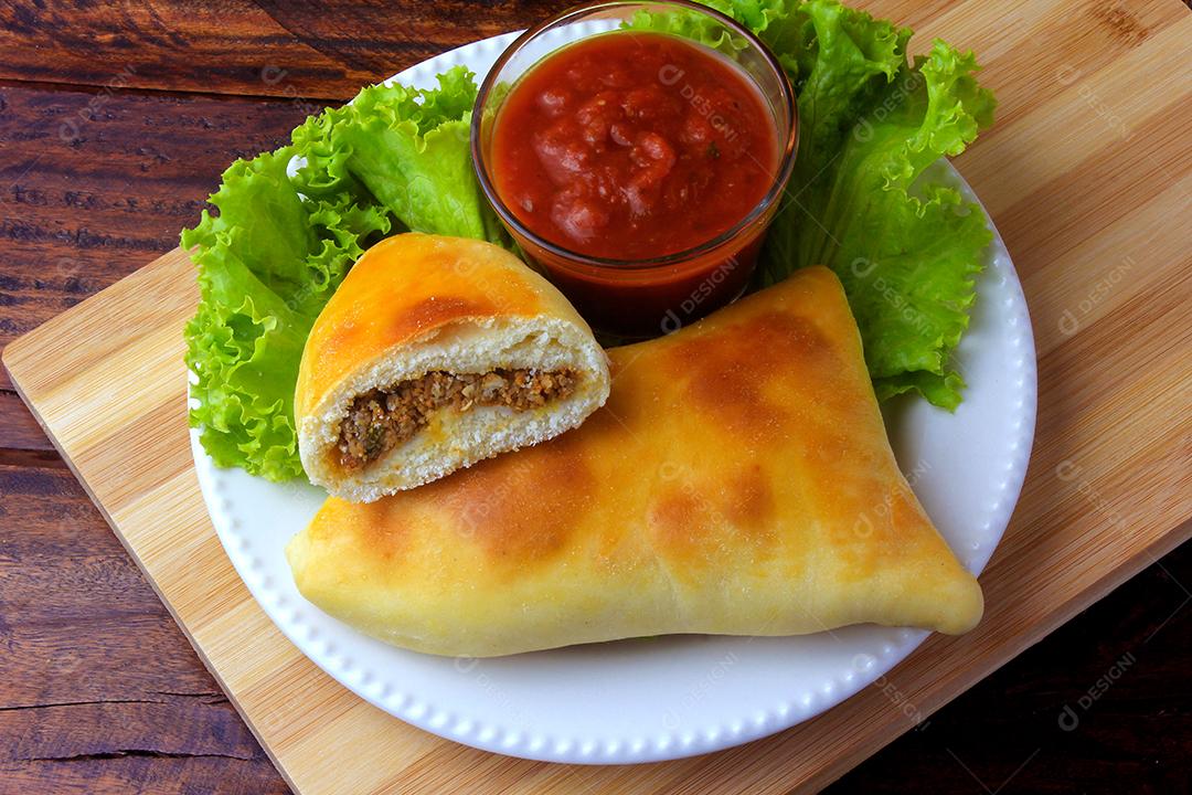 esfiha de carne (sfiha, sfeeha) de origem árabe tradicionalmente adaptada para a culinária brasileira no prato