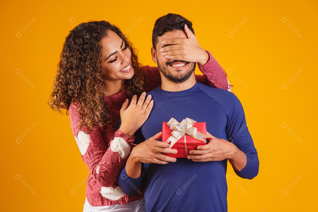 Alegre e animado jovem casal isolado sobre um amarelo