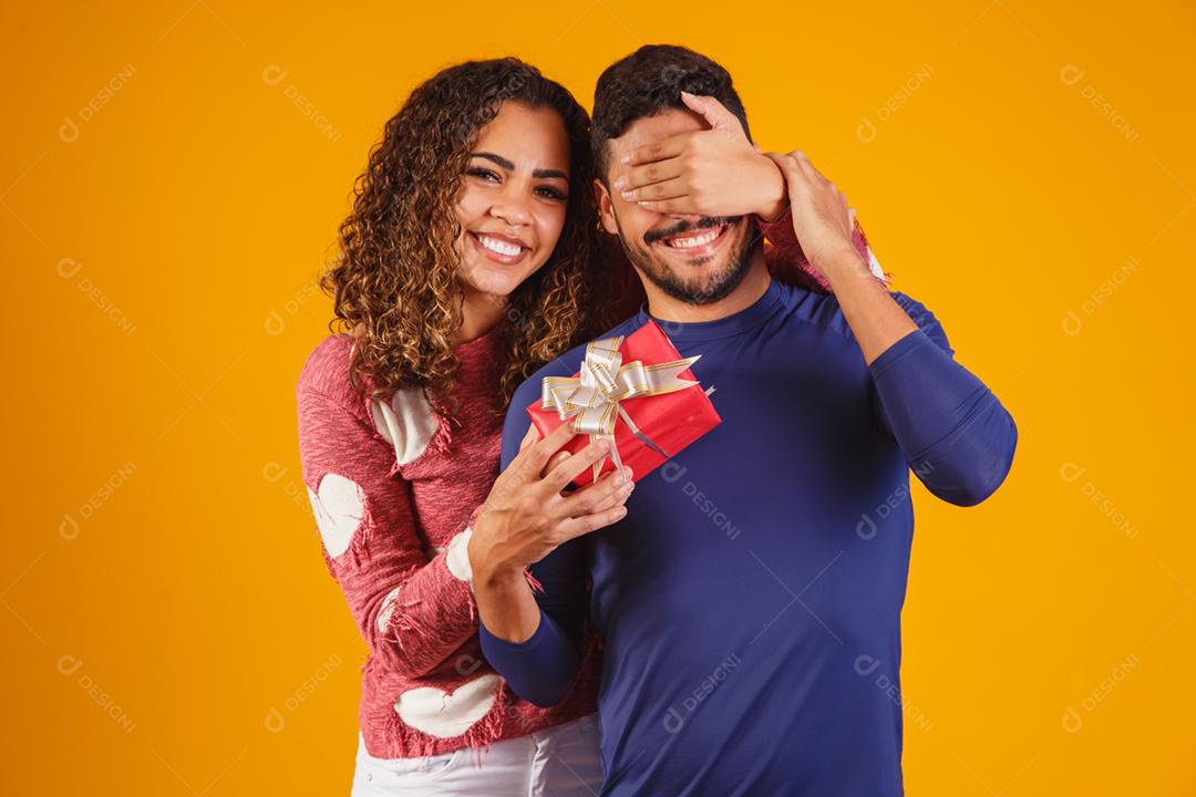 Alegre e animado jovem casal isolado sobre um amarelo