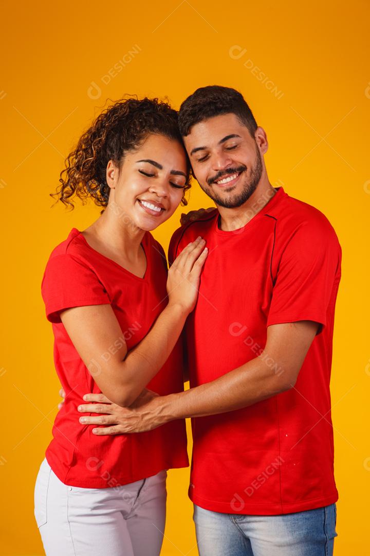 Retrato de casal de conteúdo em roupas básicas sorrindo para a câmera