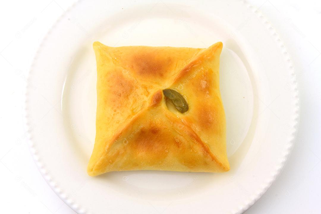 Esfiha de frango de origem árabe tradicionalmente adaptada para cozinha brasileira em prato fundo branco