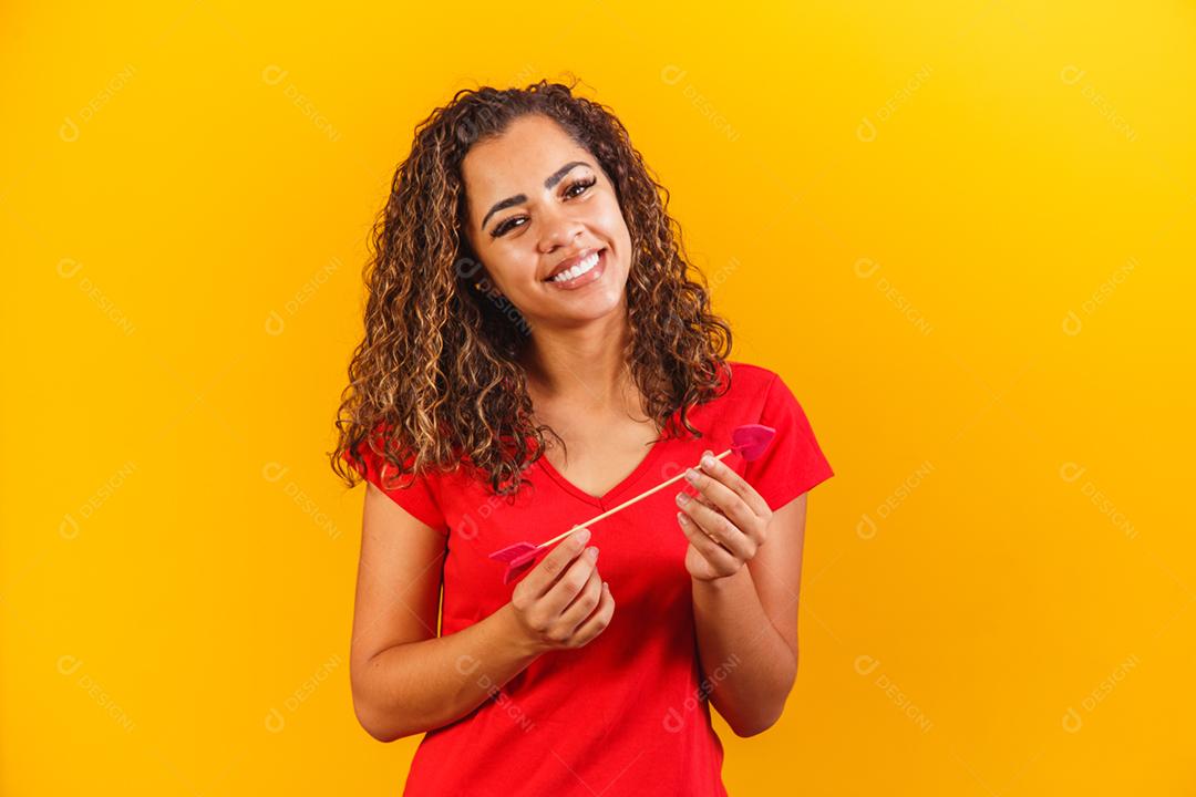 mulher afro vestida com blusa vermelha com fundo amarelo