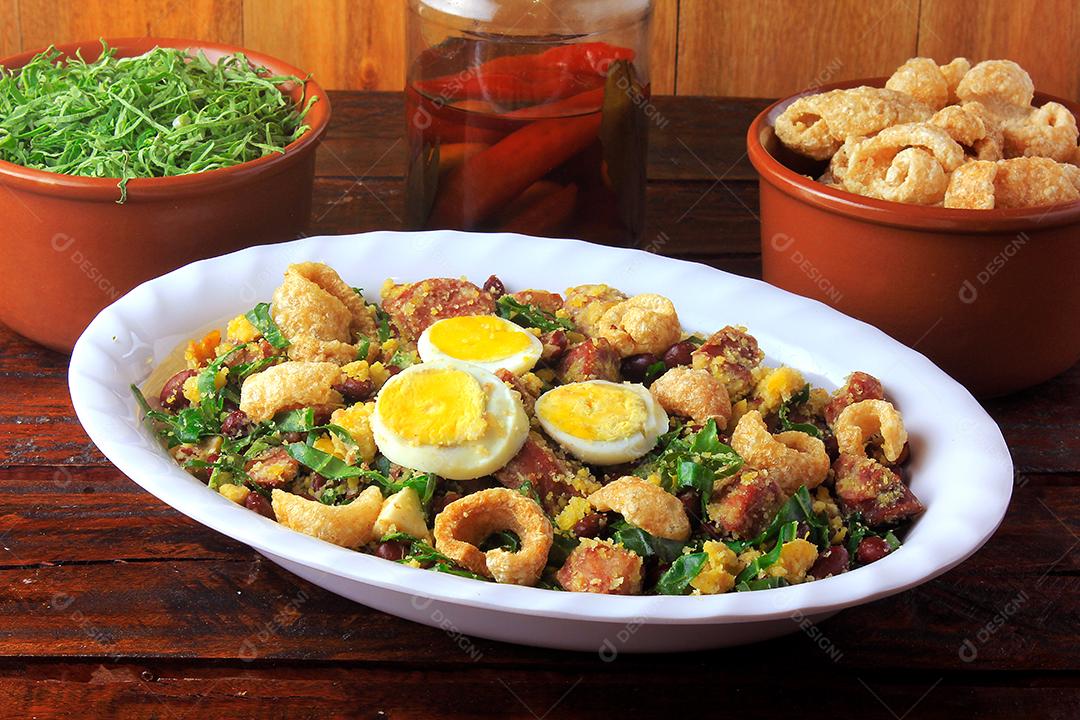 Feijão Tropeiro prato típico da culinária brasileira, feito com feijão, bacon, linguiça, couve, ovos