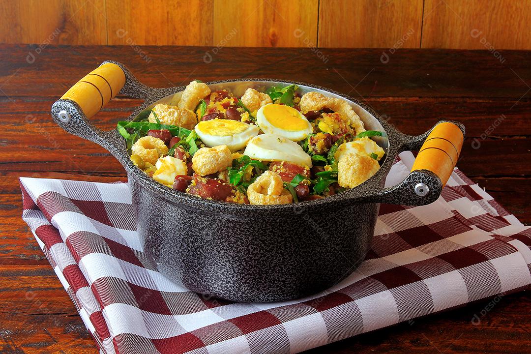 Feijão Tropeiro prato típico da culinária brasileira, feito com feijão, bacon, linguiça, couve, ovos