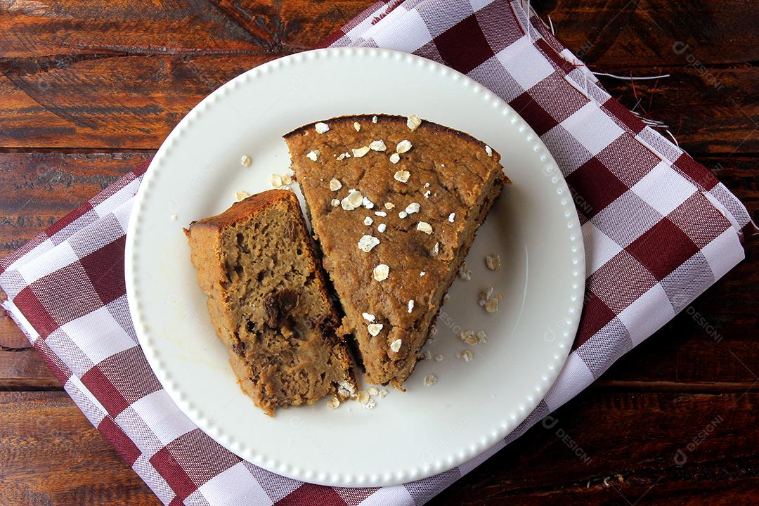 Bolo de banana caseiro saudável e passas feitas com aveia na mesa de madeira rústica. sem açúcar, sem leite